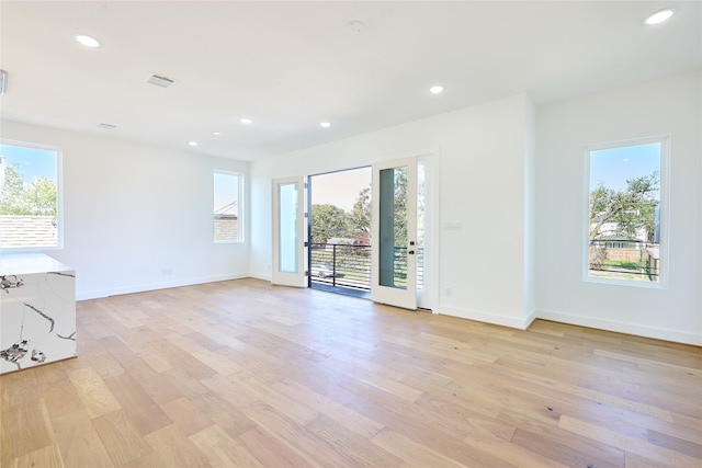 unfurnished room with light wood-type flooring and a healthy amount of sunlight