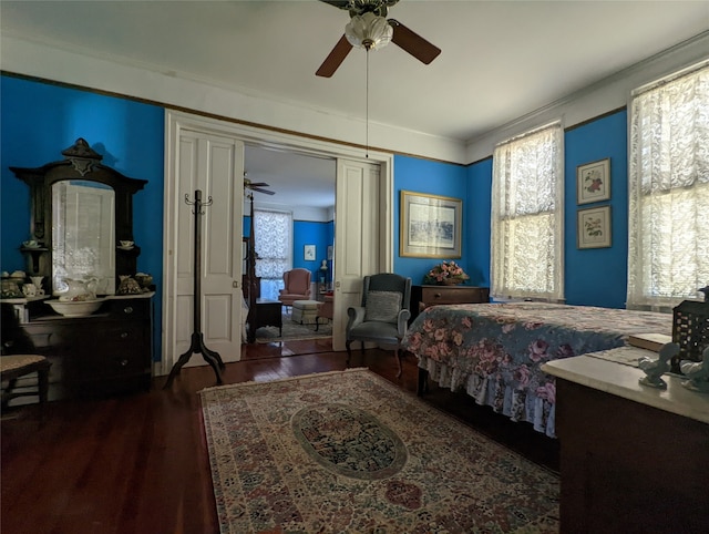 bedroom featuring dark wood-type flooring, crown molding, and ceiling fan