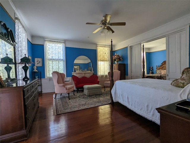 bedroom with ornamental molding, dark wood-type flooring, and ceiling fan