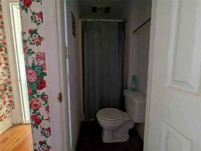 bathroom with toilet, hardwood / wood-style flooring, and a shower with shower curtain