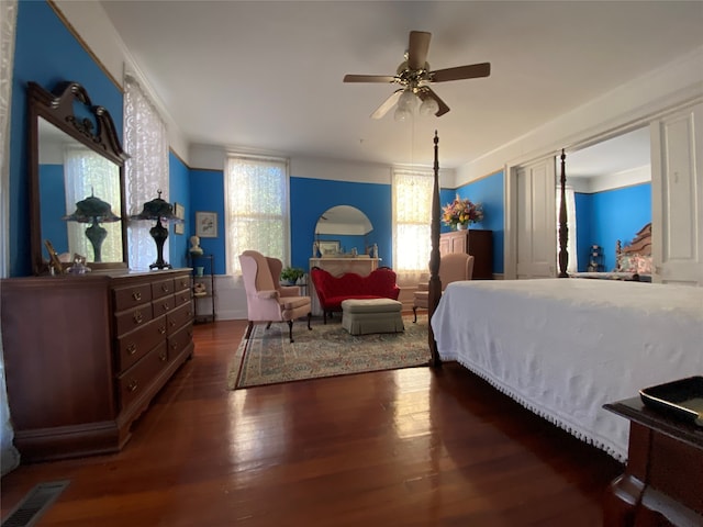 bedroom with ornamental molding, dark wood-type flooring, multiple windows, and ceiling fan