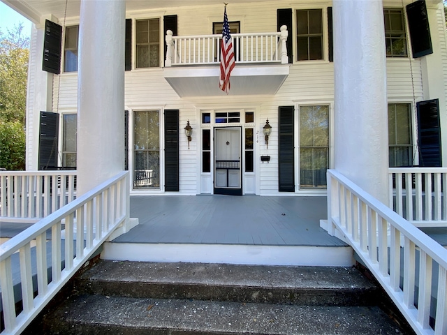 doorway to property with a porch and a balcony