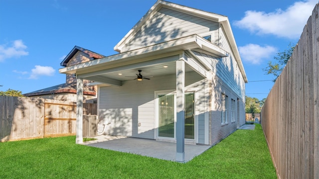 back of house with a yard, a patio, and ceiling fan