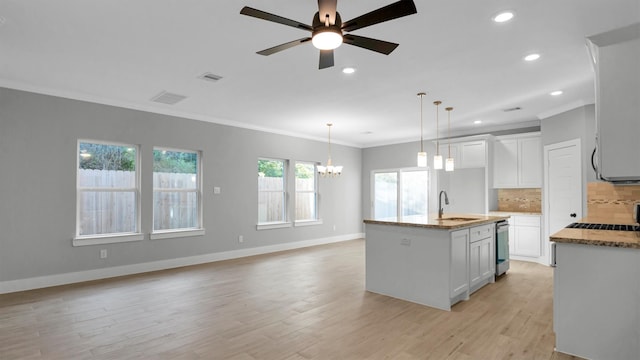 kitchen featuring white cabinetry, light hardwood / wood-style flooring, an island with sink, and pendant lighting