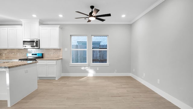 kitchen with white cabinetry, light hardwood / wood-style floors, light stone counters, and appliances with stainless steel finishes