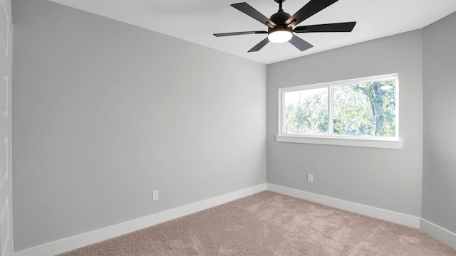 spare room with ceiling fan and light colored carpet