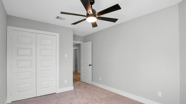 unfurnished bedroom featuring a closet, ceiling fan, and light colored carpet