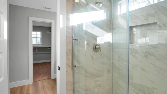 bathroom with hardwood / wood-style floors and a shower with shower door