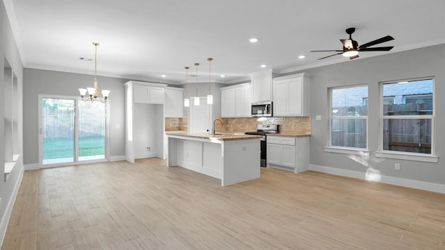 kitchen featuring white cabinetry, light wood-type flooring, hanging light fixtures, and appliances with stainless steel finishes