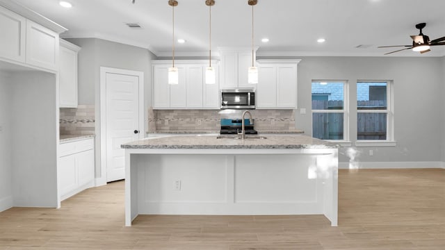 kitchen featuring white cabinets, appliances with stainless steel finishes, and light stone counters