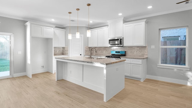 kitchen with pendant lighting, sink, light hardwood / wood-style flooring, an island with sink, and appliances with stainless steel finishes