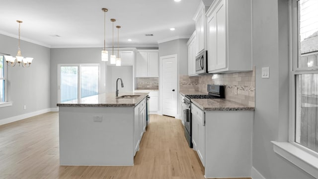 kitchen featuring white cabinets, sink, stainless steel appliances, and a kitchen island with sink