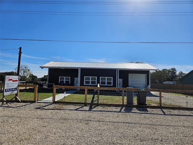 view of front of home with a garage and an outbuilding