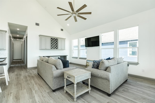 living room featuring high vaulted ceiling, ceiling fan, light hardwood / wood-style flooring, and a fireplace