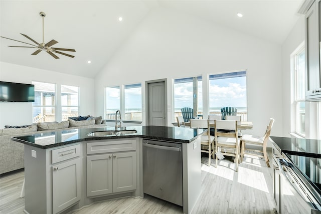 kitchen featuring sink, high vaulted ceiling, stainless steel dishwasher, and an island with sink