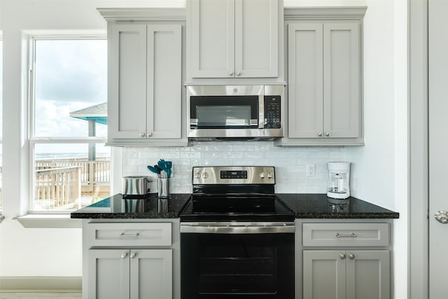 kitchen featuring dark stone countertops, gray cabinetry, and stainless steel appliances