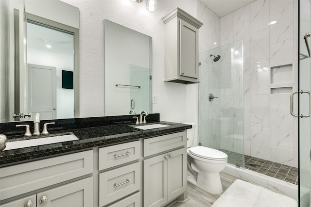 bathroom with wood-type flooring, toilet, an enclosed shower, and dual vanity