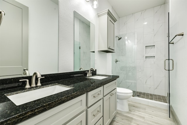 bathroom with walk in shower, toilet, and dual vanity