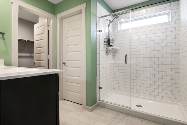 bathroom featuring tile patterned flooring, walk in shower, and vanity