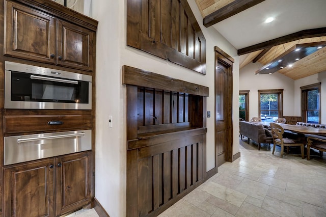 kitchen with wall oven, wood ceiling, dark brown cabinets, and lofted ceiling with beams