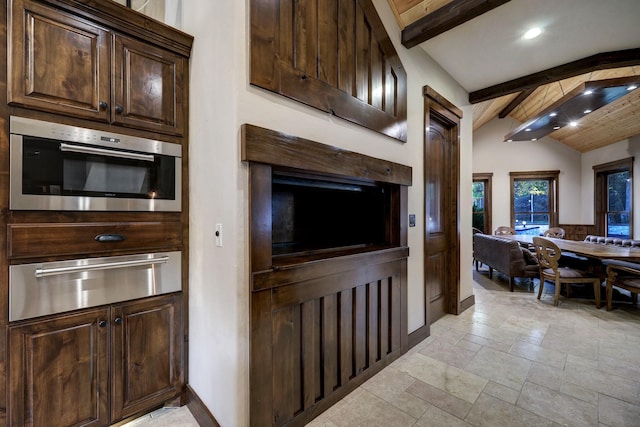 kitchen featuring lofted ceiling with beams, dark brown cabinets, and oven