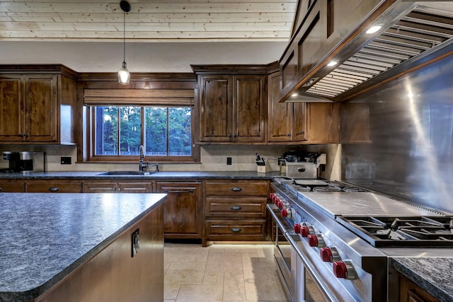 kitchen with sink, backsplash, range with two ovens, light tile patterned floors, and wall chimney exhaust hood