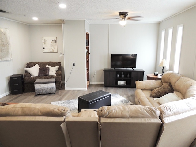 living room with a textured ceiling, ceiling fan, light wood-type flooring, and ornamental molding