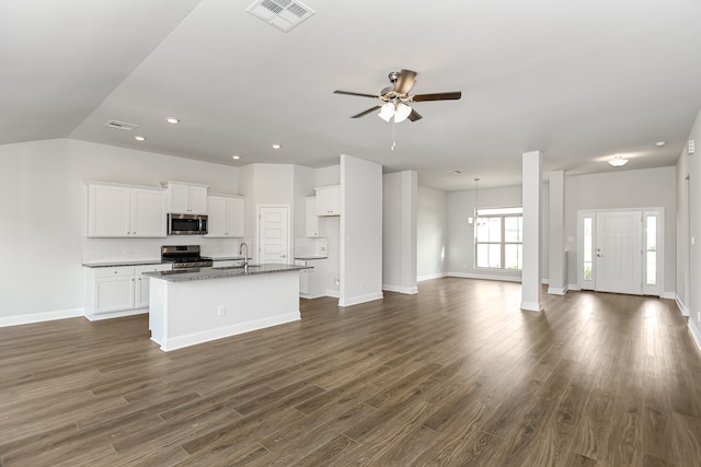 kitchen with white cabinetry, stainless steel appliances, ceiling fan with notable chandelier, an island with sink, and dark hardwood / wood-style floors