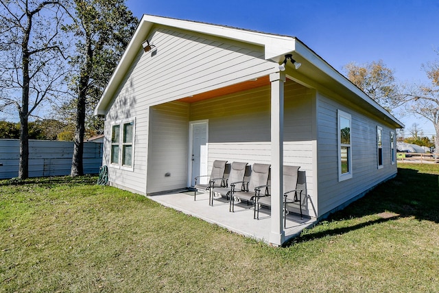 back of house with a lawn and a patio