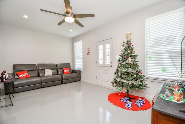 living room featuring concrete flooring, a wealth of natural light, and ceiling fan