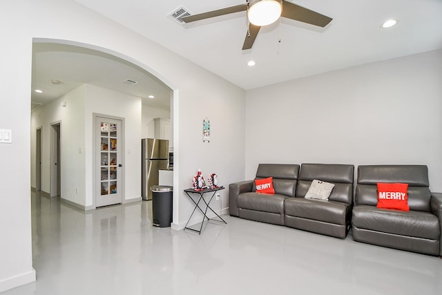 living room featuring ceiling fan and concrete floors