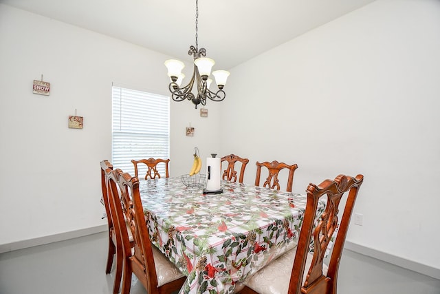 dining room with a chandelier and concrete floors