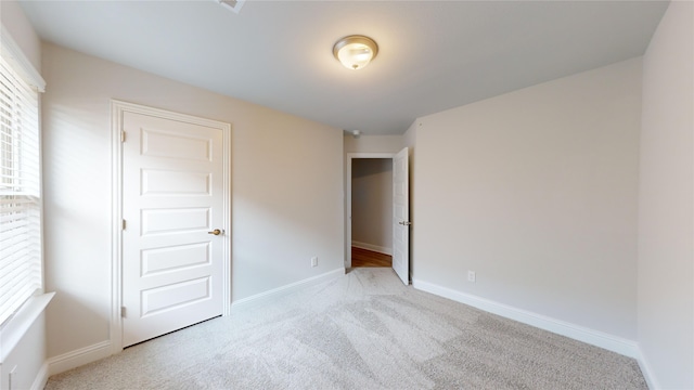 unfurnished bedroom with light colored carpet