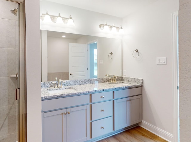 bathroom with vanity, a shower with door, and hardwood / wood-style floors