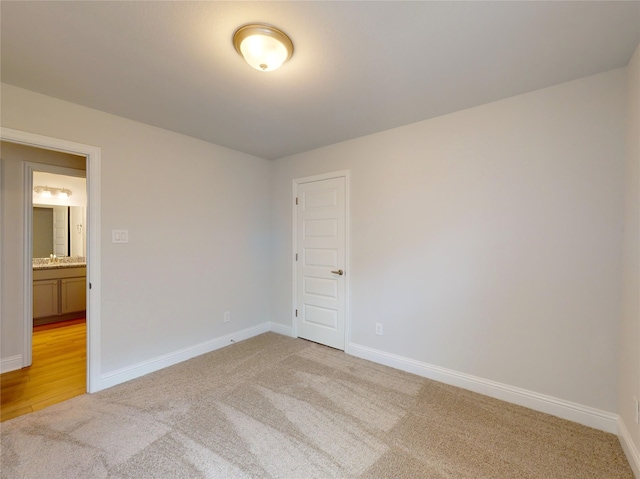 unfurnished room featuring sink and light colored carpet