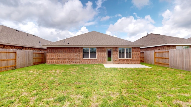 rear view of property featuring a lawn and a patio