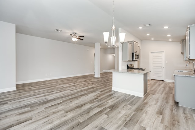 kitchen featuring stainless steel appliances, ceiling fan with notable chandelier, light wood-type flooring, and sink