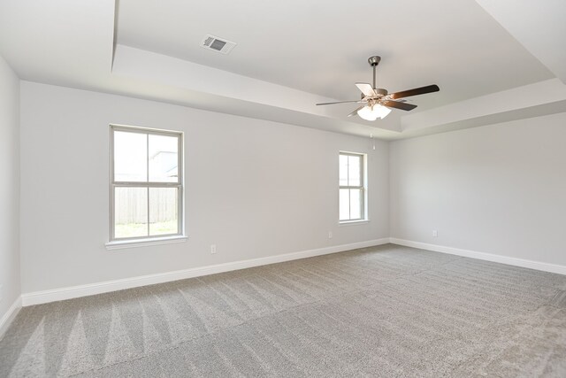 spare room featuring ceiling fan, a tray ceiling, and carpet floors