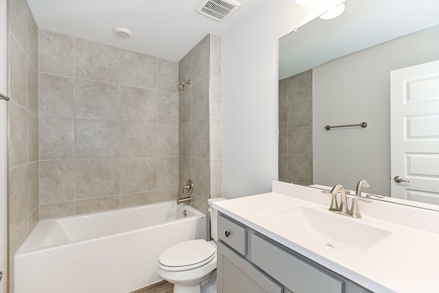 full bathroom with tiled shower / bath combo, toilet, and vanity with extensive cabinet space