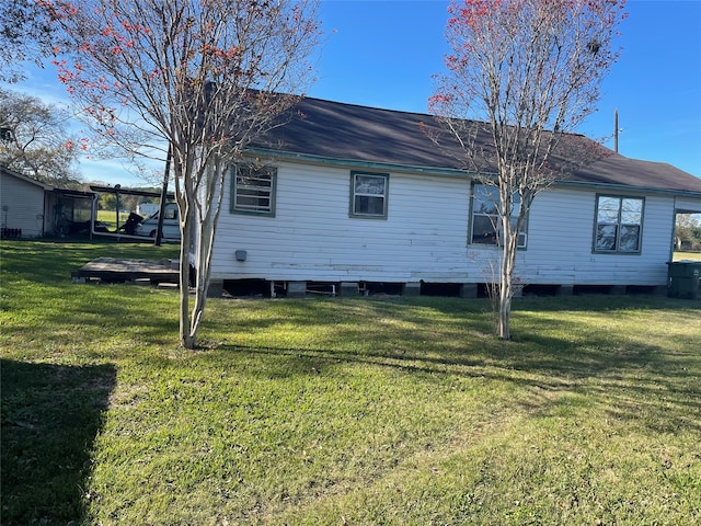 rear view of house featuring a yard and a deck