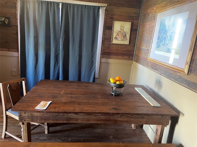 dining space featuring wood walls and wood-type flooring