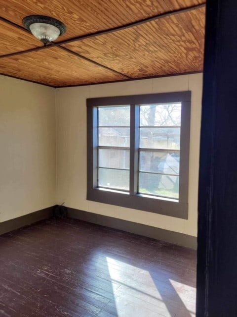 unfurnished room with hardwood / wood-style flooring and wooden ceiling