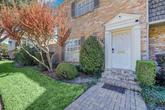 property entrance with a lawn