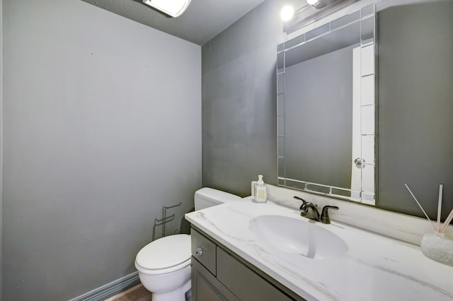 bathroom featuring vanity, a textured ceiling, and toilet