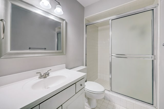 bathroom with vanity, a shower with door, toilet, and tile patterned flooring