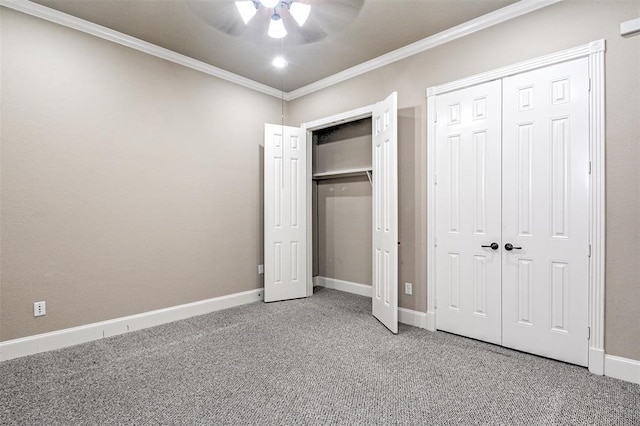 unfurnished bedroom featuring ceiling fan, crown molding, carpet, and two closets