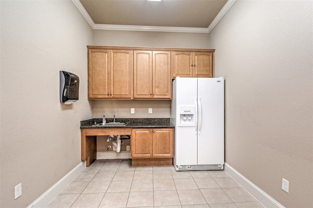 kitchen with dark stone countertops, light tile patterned floors, white refrigerator with ice dispenser, and ornamental molding