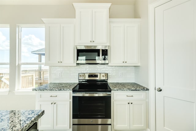 kitchen with backsplash, stone counters, stainless steel appliances, and white cabinetry