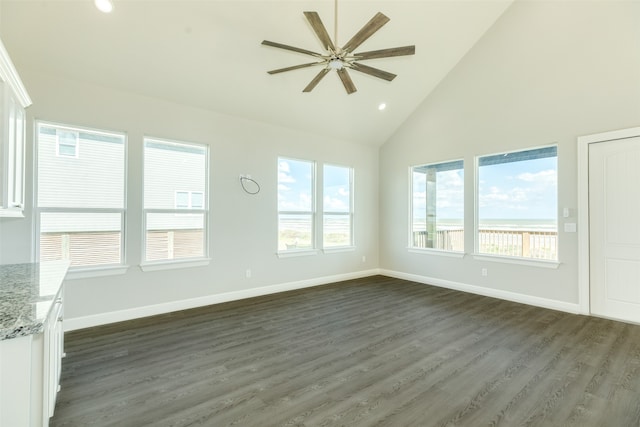 spare room with plenty of natural light, high vaulted ceiling, ceiling fan, and dark hardwood / wood-style floors