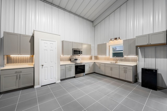 kitchen with light tile patterned flooring, stainless steel appliances, and gray cabinetry